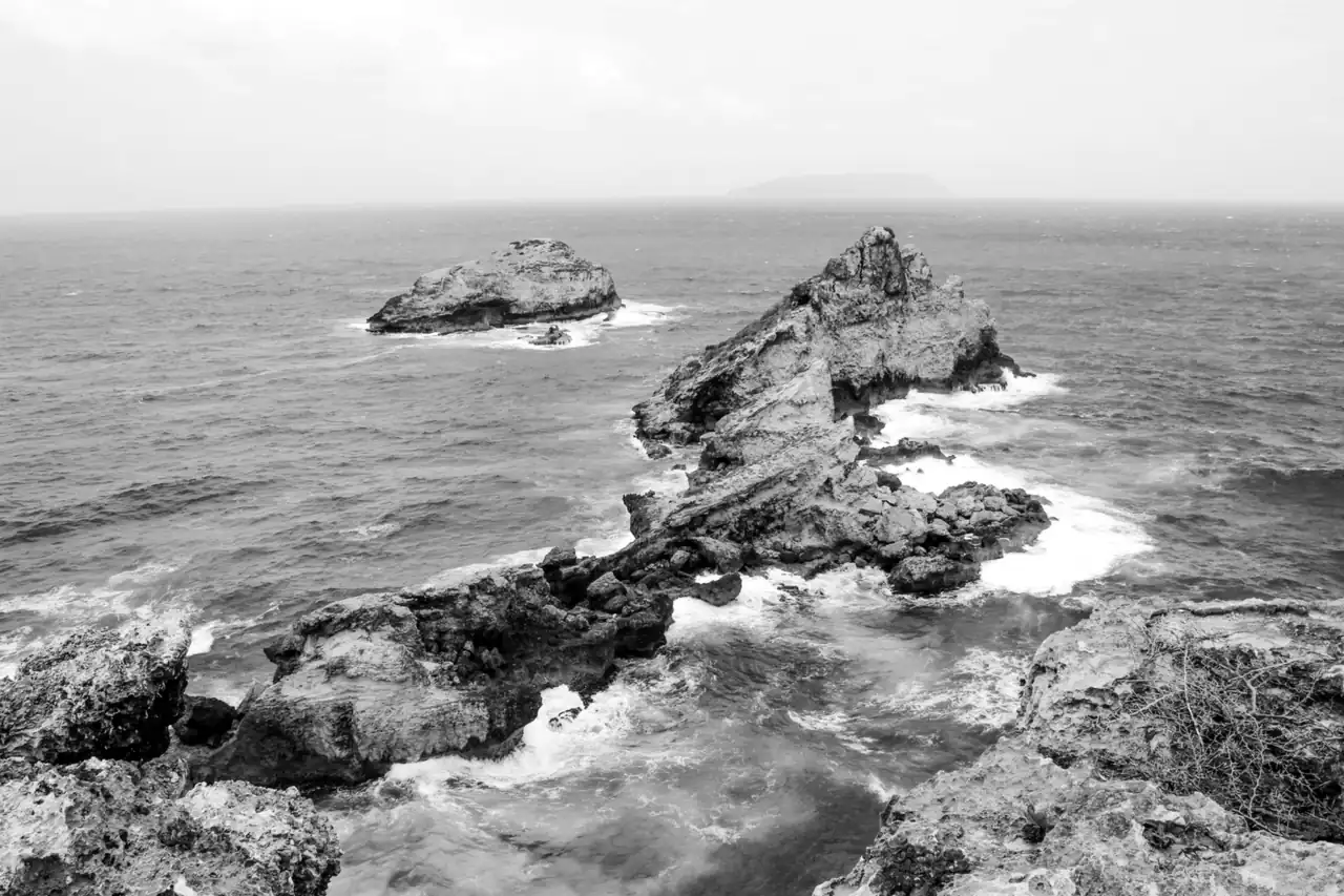A rocky outcrop running into a rough sea